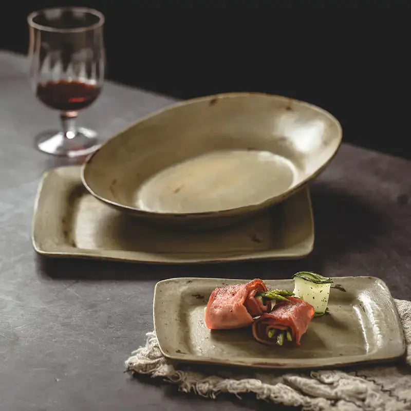 Ceramic Vintage Plates by Zendrop displayed elegantly with a glass of wine, featuring a rustic design in soft green hues.