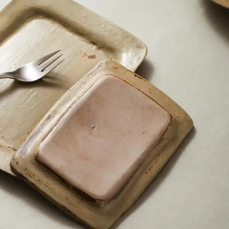 Close-up of a Ceramic Vintage Plate by Zendrop showcasing its unique texture; a square plate with a minimalist aesthetic.