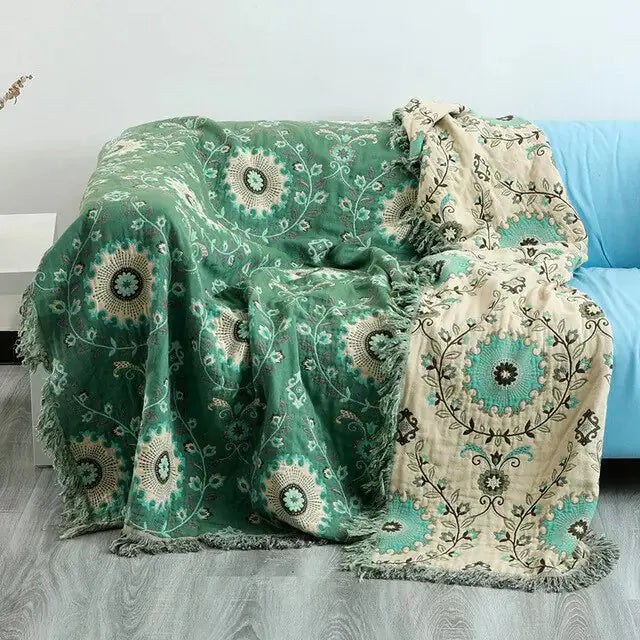 Cotton Sofa Throw Blanket by Zendrop artistically arranged on a blue couch, displaying beautiful floral patterns and textures, perfect for enhancing interior style and warmth.