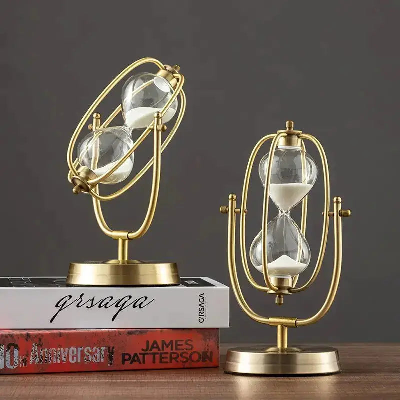 Stylish Aurelius Hourglass Timer by Zendrop on a bookshelf, featuring a 360° rotating brass design and clear glass chambers.