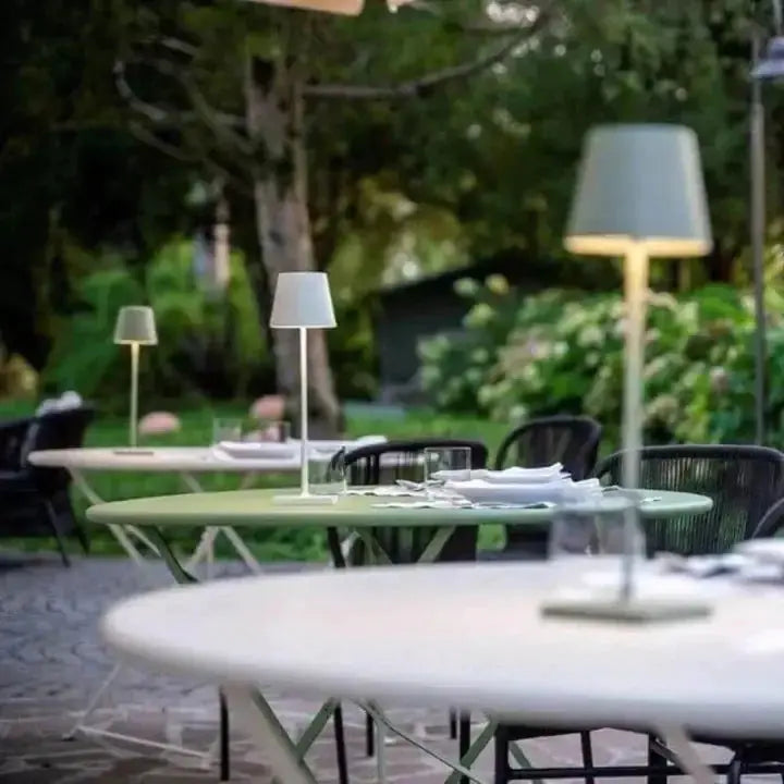 Outdoor setting featuring cordless lamps on tables, creating a cozy ambiance for dining, by Zendrop.
