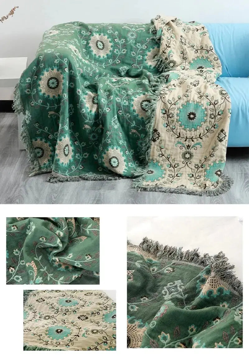 Cozy Cotton Sofa Throw Blanket by Zendrop draped over a blue sofa, featuring intricate floral patterns in shades of green and beige, adding a stylish touch to any living space.