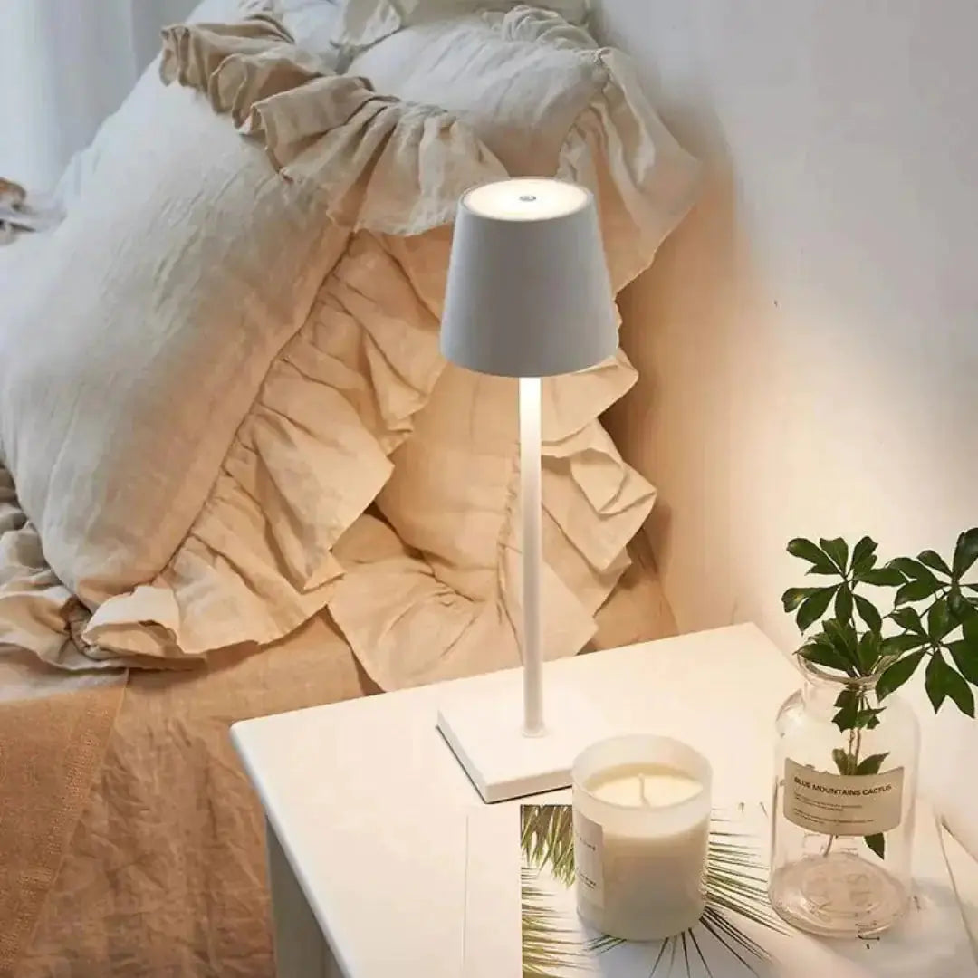 Chic white cordless lamp by Zendrop positioned on a nightstand, enhancing a serene bedroom atmosphere with its soft illumination.